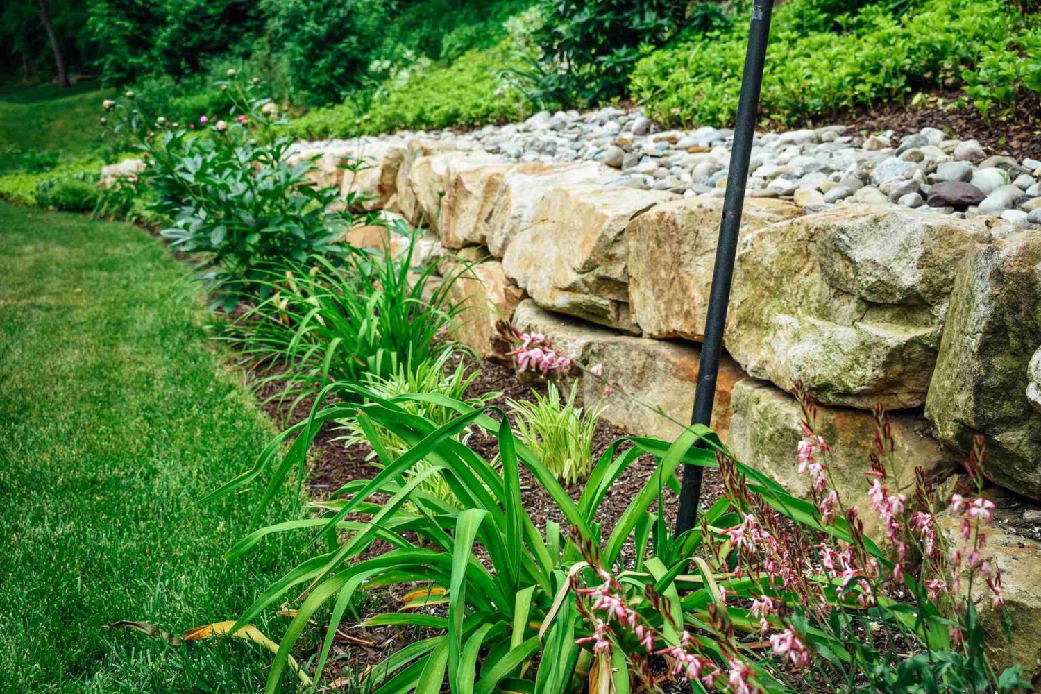 Curved stone retaining wall by garage