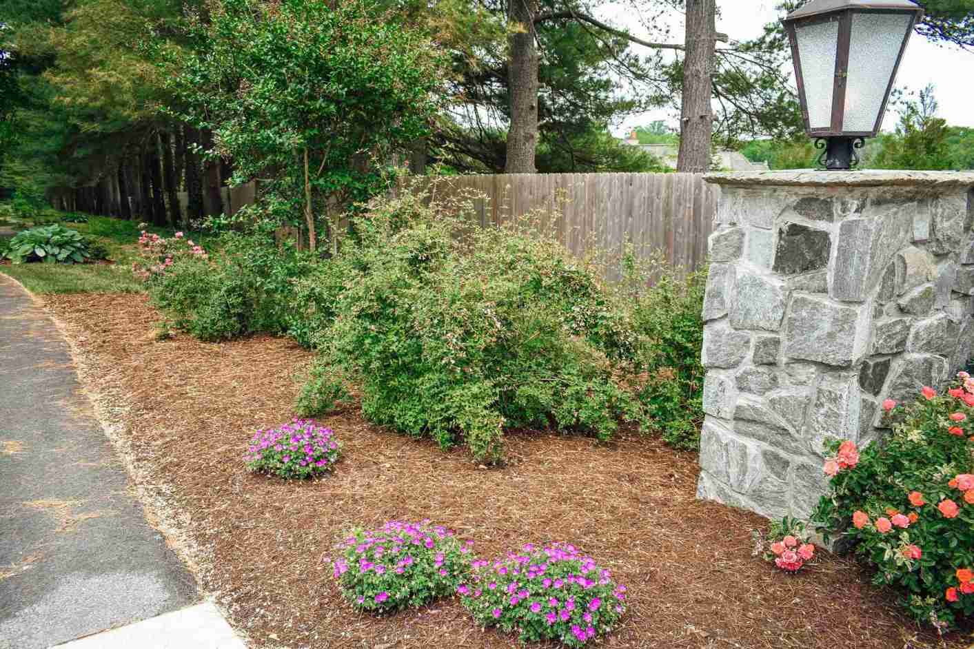 Professional spring bulb installation with stone pillars and flower beds in Chester County