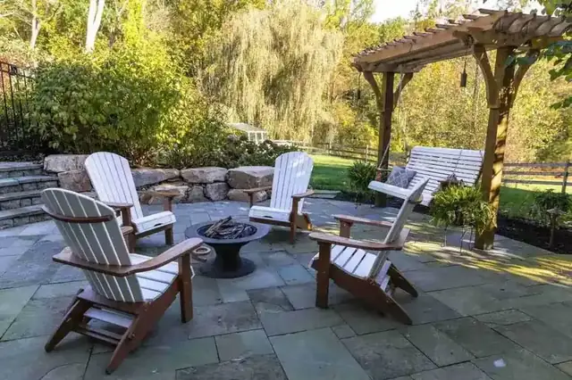 Natural stone patio with built-in grill area and waterfall view